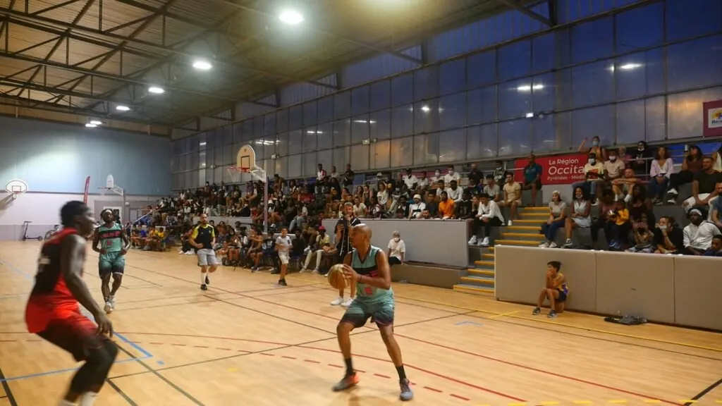 Le gymnase Jean Bouin pendant un match, tribunes pleines, un joueur ballon en main