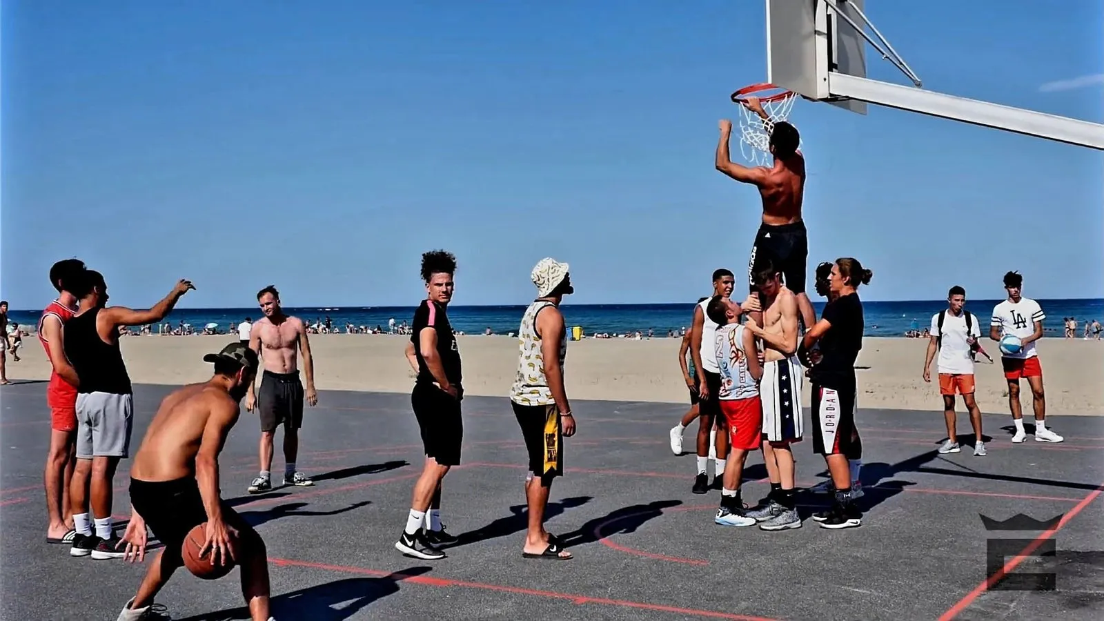 Un playground en bord de mer, un joueur accroché à l'arceau après un dunk, entouré des autres