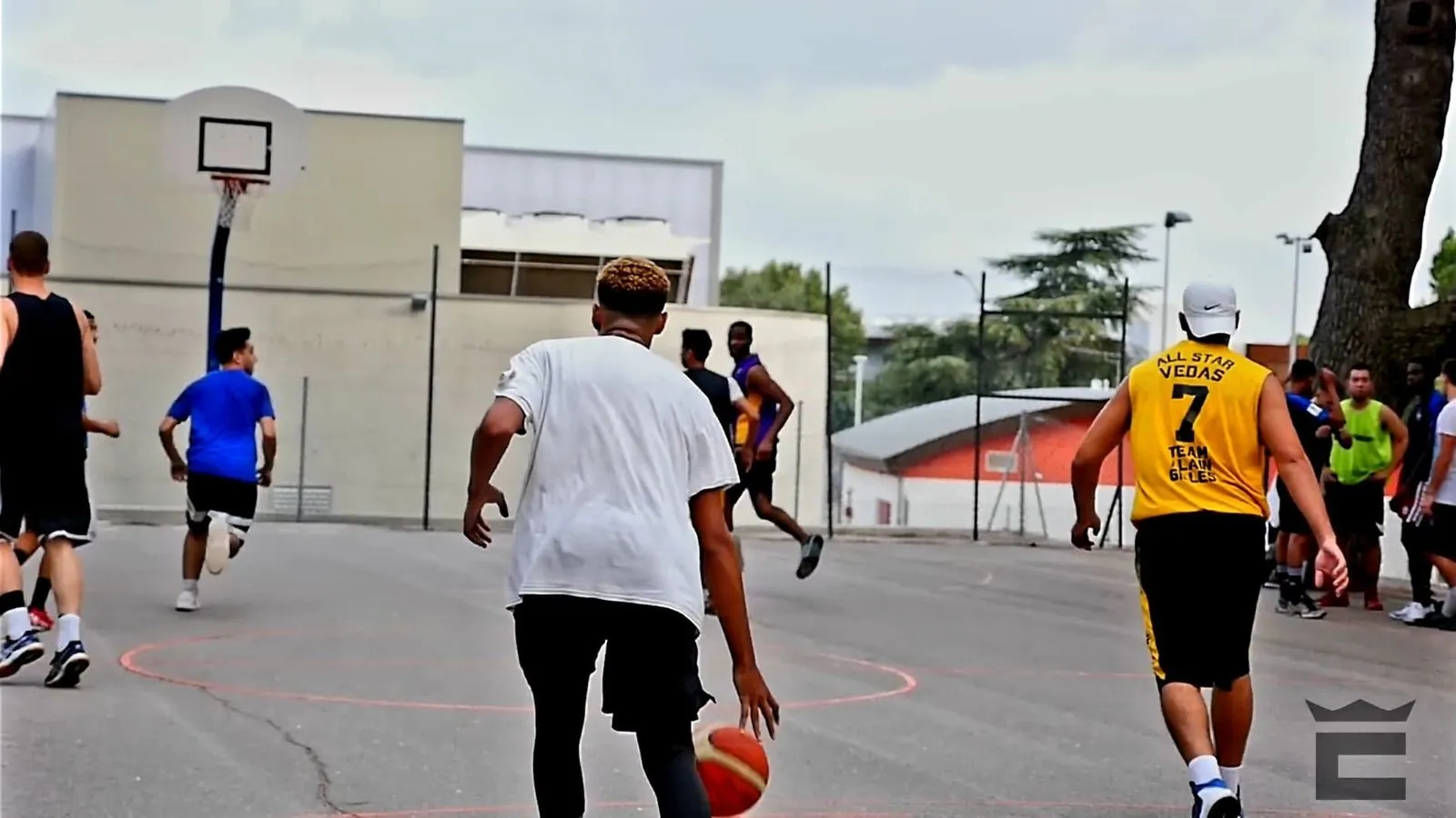 Un match sur un city stade, ballon au sol, joueurs en mouvement